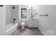 Well-lit bathroom with white fixtures, and contemporary vanity that includes a tub and shower at 412 Jefferson Dr, Charlotte, NC 28270