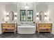 Bright bathroom features a soaking tub between two floating wood vanities with black marble flooring at 412 Jefferson Dr, Charlotte, NC 28270