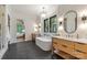 Bright bathroom features a soaking tub between dual vanities and a glass-enclosed shower and a door to the bedroom at 412 Jefferson Dr, Charlotte, NC 28270