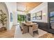 Bright dining room featuring a wood table, modern chandelier, and large windows with green lawn views at 412 Jefferson Dr, Charlotte, NC 28270