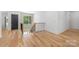 Bright hallway featuring hardwood floors, modern railing, and an elegant chandelier in a home's interior at 412 Jefferson Dr, Charlotte, NC 28270