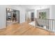 Bright hallway with hardwood floors, staircase, and a glimpse into a stylishly furnished living area at 412 Jefferson Dr, Charlotte, NC 28270