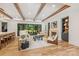 Open-concept living area with wood beam ceilings, fireplace, and a large sliding glass door to the exterior at 412 Jefferson Dr, Charlotte, NC 28270