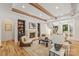 Comfortable living room with a stone fireplace, built-in bookcases, wood beam ceiling, and access to the staircase at 412 Jefferson Dr, Charlotte, NC 28270