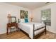Bright bedroom features a wooden-frame bed, a quaint vanity, and a sunlit window at 4801 Pennant Pl, Charlotte, NC 28212