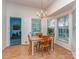 Bright dining room featuring a chandelier, wooden table with four chairs, and large windows at 4801 Pennant Pl, Charlotte, NC 28212