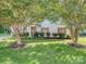 Charming home with a well-maintained front yard, lush lawn, mature trees, and an American flag at 4801 Pennant Pl, Charlotte, NC 28212