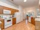 Efficient kitchen layout featuring white appliances, wood cabinets, and a view into the dining area at 4801 Pennant Pl, Charlotte, NC 28212