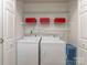 Functional laundry area with washer, dryer, and wire shelving for storage at 4801 Pennant Pl, Charlotte, NC 28212
