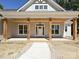 Inviting front porch featuring wood pillars, wood ceiling, a hanging light, and a modern white front door at 501 E Cj Thomas Rd # 1, Monroe, NC 28110