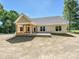 Rear view of the home featuring a covered patio and well-maintained exterior, surrounded by trees and greenery at 501 E Cj Thomas Rd # 1, Monroe, NC 28110