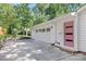 Exterior view of a white garage featuring a pink door, offering both parking and curb appeal at 5611 Robinhood Rd, Charlotte, NC 28211