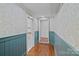Hallway featuring hardwood floors, wainscoting, and patterned wallpaper at 5611 Robinhood Rd, Charlotte, NC 28211