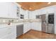 Charming kitchen featuring white cabinets, stainless steel appliances, and wood flooring at 5611 Robinhood Rd, Charlotte, NC 28211