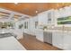 Bright kitchen with white cabinets, stainless appliances, hardwood floors, and a wood-planked ceiling at 5611 Robinhood Rd, Charlotte, NC 28211