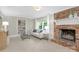 Cozy living room featuring a brick fireplace, neutral decor, and a built in bookcase at 5611 Robinhood Rd, Charlotte, NC 28211