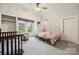 Cozy bedroom with whimsical carriage bed, crib and chair, illuminated by natural light at 626 Cabarrus W Ave, Concord, NC 28027