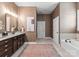 Bathroom featuring a tub, dark wood vanity with granite counters, and warm-toned walls at 6506 Jepson Ct # 349, Charlotte, NC 28214