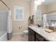 Bright bathroom featuring a granite countertop, dark cabinets, and a shower-tub combo at 6506 Jepson Ct # 349, Charlotte, NC 28214