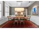 Formal dining room featuring a rustic wood table, gray walls, and white trim, illuminated by modern lighting at 6506 Jepson Ct # 349, Charlotte, NC 28214