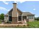 Back of home exterior highlighting the screened in porch and outdoor stone fireplace at 6506 Jepson Ct # 349, Charlotte, NC 28214