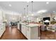 Open kitchen with a center island, hardwood floors, stainless steel appliances, and access to the living and dining areas at 6506 Jepson Ct # 349, Charlotte, NC 28214