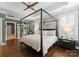 Calming main bedroom featuring a canopy bed, tray ceiling, hardwood floors, and plantation shutters at 6506 Jepson Ct # 349, Charlotte, NC 28214