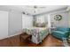 Cozy bedroom with hardwood floors, a ceiling fan, closet and a matching wicker bench and blue armchair at 7029 Forest Hills Dr # 38, Denver, NC 28037