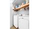 Laundry room with a washer and dryer, a shelf with laundry supplies, and a white door at 7029 Forest Hills Dr # 38, Denver, NC 28037