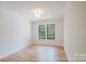 Bright bedroom boasts hardwood floors, black window trim, and neutral walls at 705 Mcalway Rd, Charlotte, NC 28211