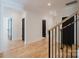 Open hallway features hardwood floors, modern black doors, and stairway at 705 Mcalway Rd, Charlotte, NC 28211