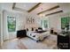 Serene main bedroom with wood-beamed ceilings, large windows, and stylish decor, creating a relaxing retreat at 705 Mcalway Rd, Charlotte, NC 28211
