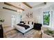 Bright main bedroom with white walls, wood beams, modern lighting, and a neutral area rug at 705 Mcalway Rd, Charlotte, NC 28211