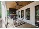 Covered porch with a ceiling fan, fireplace, and ample seating creating a cozy outdoor retreat at 705 Mcalway Rd, Charlotte, NC 28211