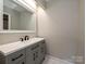 Modern bathroom featuring gray vanity with dual sinks, and contemporary fixtures and large mirror at 7916 Charter Oak Ln, Charlotte, NC 28226