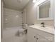 Bright bathroom featuring a shower-tub combo with white tile surround and modern vanity with sink at 7916 Charter Oak Ln, Charlotte, NC 28226