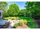 Picturesque backyard featuring lush greenery, brick patio, and outdoor fire pit at 8102 Bergen Ct, Waxhaw, NC 28173