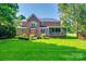 Expansive backyard with lush lawn, mature trees, brick patio, and screened porch at 8102 Bergen Ct, Waxhaw, NC 28173