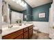 Well-lit bathroom featuring double sinks, wood cabinets, and a shower-tub combo at 8102 Bergen Ct, Waxhaw, NC 28173