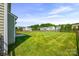 Large, grassy backyard with a playground and fence visible in the distance at 8312 Compton Acres Ln, Waxhaw, NC 28173