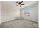 Light-filled bedroom features a stylish accent wall, neutral carpet, and a view of the neighborhood at 8312 Compton Acres Ln, Waxhaw, NC 28173
