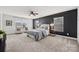 Spacious main bedroom with a modern accent wall, ceiling fan, and bright windows at 8312 Compton Acres Ln, Waxhaw, NC 28173