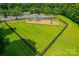 Community playground with swings and slide, surrounded by green space and a black fence at 8312 Compton Acres Ln, Waxhaw, NC 28173