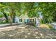 Cozy one-story house boasting a bright blue door and a cute, covered porch with stairs leading to the basement at 909 Gibbons St, Gastonia, NC 28052