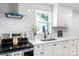 Bright modern kitchen with stainless steel appliances, white cabinets, and a view of the backyard at 909 Gibbons St, Gastonia, NC 28052
