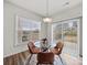 Bright dining area with a glass table and seating for four, overlooking the backyard at 9582 Creighton Nw Rd, Concord, NC 28027
