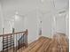 Upstairs hallway featuring hardwood floors and access to multiple rooms at 9582 Creighton Nw Rd, Concord, NC 28027