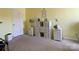 Bedroom featuring neutral carpet, yellow walls, and stylish white shelving and side tables at 9608 Brackenview Ct, Charlotte, NC 28214