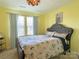 Bedroom featuring a bed with seashell pattern bedding, two windows, and yellow walls at 9608 Brackenview Ct, Charlotte, NC 28214