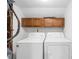 Bright laundry area with white appliances, upper cabinet, and utility access at 9639 Green Gable Ct, Charlotte, NC 28270
